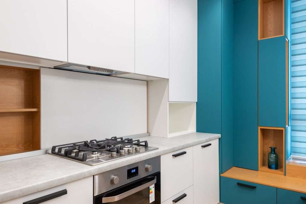 pexels-photo-6956118 White cabinet with gas stove and empty shelves against jalousie in contemporary light house